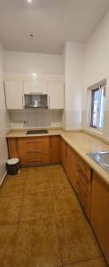 an empty kitchen with wooden cabinets and a sink at Modern Secured Condo Apartments 1 in Tema +58 photos