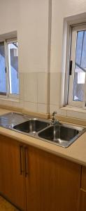 a kitchen with a sink and two windows at Modern Secured Condo Apartments 1 in Tema