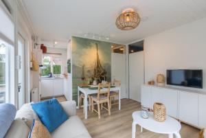 a living room with a couch and a table at Welcome in - Vakantiewoning met zonnige tuin, dichtbij zee en strand I Noordendolfer 2-49 in Zoutelande
