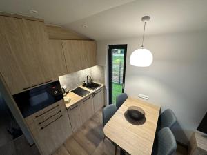 a small kitchen with a table and a sink at Domek Przy Jeziorze in Kujanki +9 photos