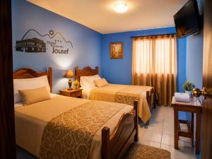 a hotel room with two beds and a sign on the wall at Hotel Jousef in Puquio