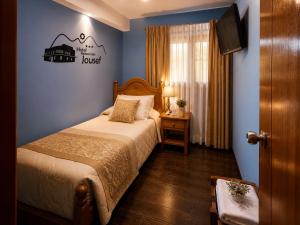 a bedroom with a bed and a sign on the wall at Hotel Jousef in Puquio