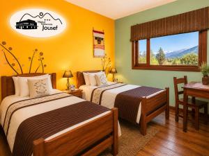 a hotel room with two beds and a table at Hotel Jousef in Puquio