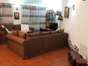 a living room with a brown couch and a tv at Casa Rural La Hoyita de Tunte in San Bartolomé