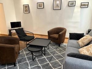 a living room with a couch and chairs and a table at Le musée Fabre, appart de charme , parking gratuit in Montpellier