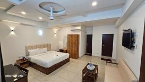 a bedroom with a bed and a couch and a tv at Sky Residency Lodge in Trichūr