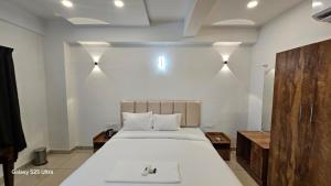a bedroom with a large white bed in a room at Sky Residency Lodge in Trichūr