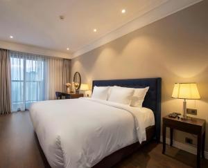a bedroom with a large white bed and a window at Bow Luxury 3 in Danang +15 photos