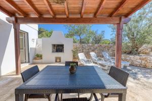 a patio with a table and chairs and a fireplace at Villa Elena in Marina di Pescoluse