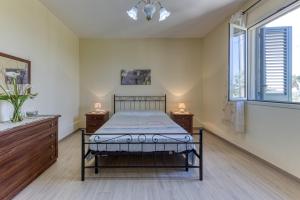 a bedroom with a bed and two dressers and a window at Villa Elena in Marina di Pescoluse