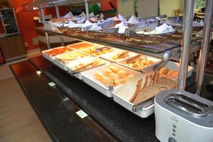 un buffet lleno de diferentes tipos de pan en Green Hotéis, en Cabo Frío