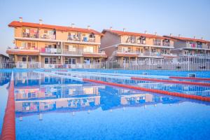 a hotel swimming pool with buildings in the background at Morski Duni in Shkorpilovtsi