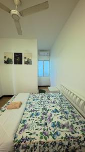a bedroom with a large bed with a floral bedspread at Hm home 2 in Sepang