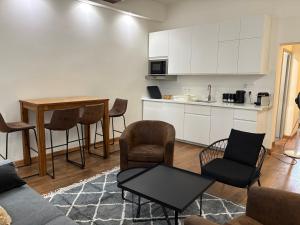 a living room with a table and chairs and a kitchen at Le musée Fabre, appart de charme , parking gratuit in Montpellier