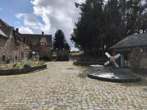 a stone courtyard with a monument in front of a house at Maisonnette meublée à la campagne in Ernée