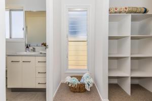 a bathroom with white cabinets and a sink at 10 Beach Houses in Agnes Water +38 photos