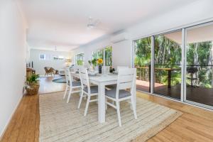 a dining room with a white table and chairs at 10 Beach Houses in Agnes Water