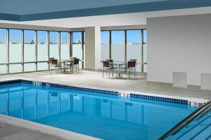 a swimming pool with chairs and tables in a building at Homewood Suites by Hilton Washington DC NoMa Union Station in Washington, D.C.