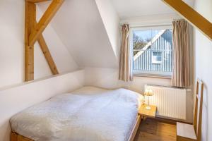 a small bedroom with a bed and a window at Ferienhaus Haussee in Himmelpfort