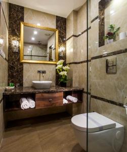 uma casa de banho com um lavatório, um WC e um espelho. em Hotel Sunstar Heritage em Nova Deli
