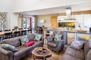 a living room and kitchen with couches and a table at Ferienhaus Haussee in Himmelpfort