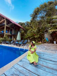 a woman in a yellow dress sitting next to a pool at Awesome Place in Ella