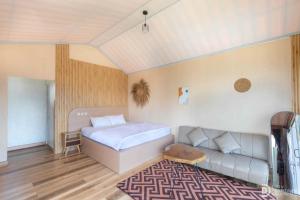 a bedroom with a bed and a couch at Fortune Glamping in Diyeng