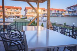 a table and chairs on a balcony with buildings at Morski Duni in Shkorpilovtsi +13 photos