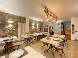 a restaurant with tables and chairs and a stone wall at Locanda Cà de Rusitta in Vezzi Portio
