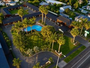 an overhead view of a resort with a swimming pool and palm trees at Teal Motor Lodge in Gisborne