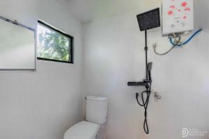 a bathroom with a toilet and a phone on the wall at Fortune Glamping in Diyeng