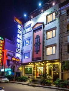 a building with neon signs on a street at night at Hotel Sunstar Heritage in New Delhi