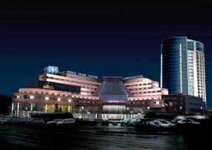 un gran edificio con coches estacionados frente a él en Atrium Palace Hotel en Yekaterinburg