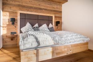 a bedroom with a large bed with a wooden wall at Chalet Schintlbauer in Annaberg im Lammertal
