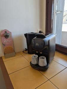 a coffee machine sitting on a floor with two mugs at Appartement de charme in Concarneau +5 photos