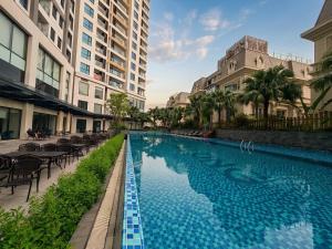 a swimming pool with tables and chairs next to buildings at Luxury Ocean View Apartments - The Sapphire Ha Long, Studio & 2BR in Ha Long
