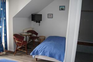 a bedroom with a bed and a table and chairs at Aux Trois Jean in Le Crotoy