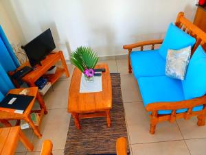 ein Wohnzimmer mit einem blauen Sessel und einem Tisch in der Unterkunft Chepsted Chalets in Glacis