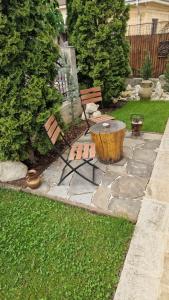 a garden with a log table and two benches at Casa Teo in Buzău