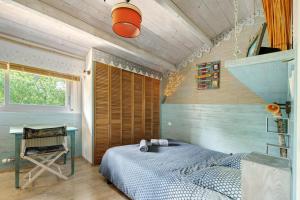 a bedroom with a bed and a desk in it at Vacances chez Cali - Maison 10 pers in La Séguinière
