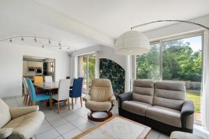 a living room with a couch and a dining room at Vacances chez Cali - Maison 10 pers in La Séguinière