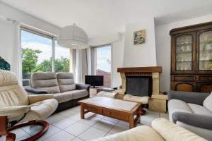 a living room with couches and a fireplace at Vacances chez Cali - Maison 10 pers in La Séguinière