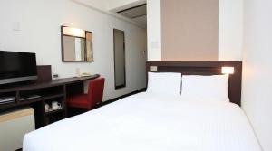a bedroom with a bed and a desk and a television at Urban Hotel Kyoto in Kyoto