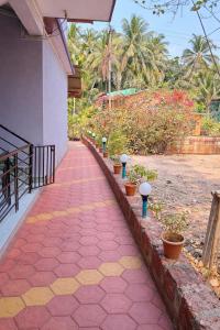 a red brick walkway with potted plants next to a building at The Triple Nest in Gokarna