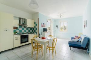 a kitchen and living room with a table and chairs at Casa Celeste a Torre dell'Orso in Torre dell'Orso