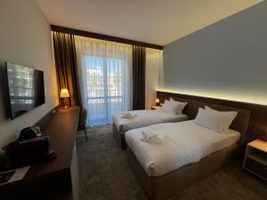 a hotel room with two beds and a television at Hotel Onogošt in Nikšić +46 photos