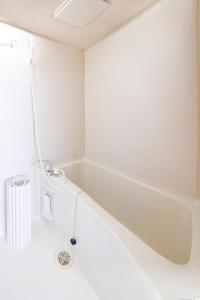 a bathtub in a bathroom with white walls at ラベンダー富士 富士山と過ごすおしゃれな隠れ家 in Fuji