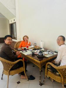 a group of three people sitting around a table at Ashur Bobo in Samarkand