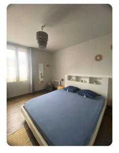a bedroom with a large blue bed in it at Le Nî’ De Jess in Migennes