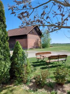 two benches sitting in front of a barn at Pivní lednice in Lhota pod Libčany